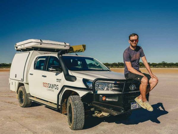 Ein Mann sitzt auf einem Geländewagen im Outback von Australien